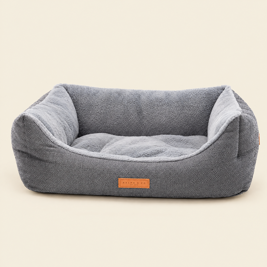 The Balmoral grey herringbone bolster bed by Ralph & Co on a cream background