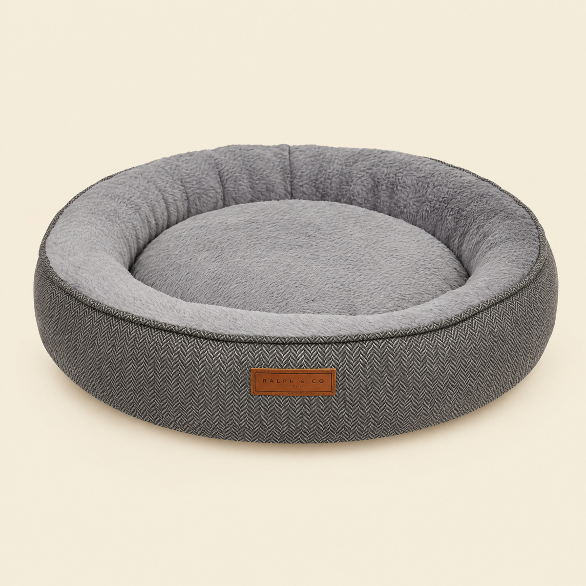 The Balmoral herringbone calming donut bed by Ralph & Co on a cream background