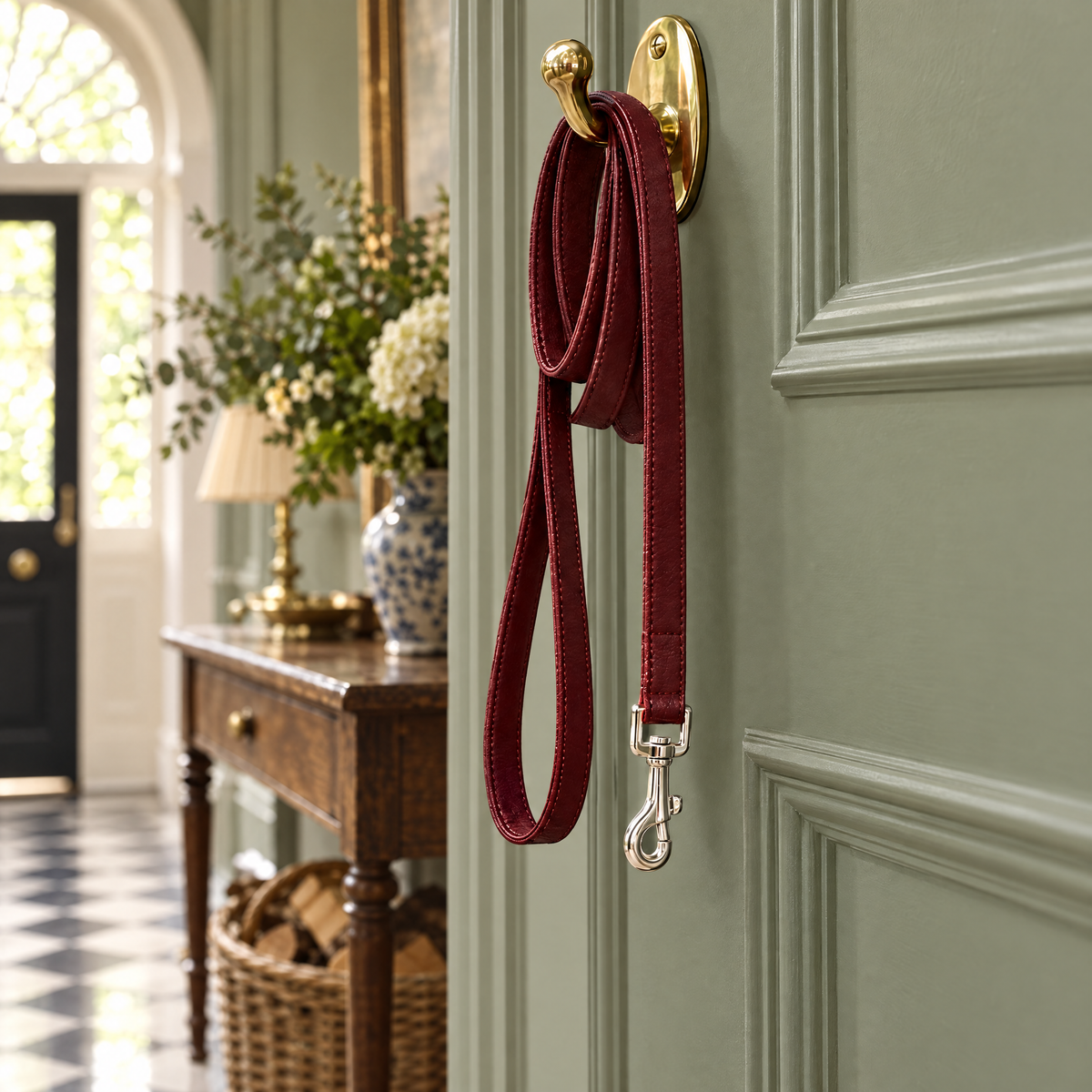 The Oxblood Red Vegan Leather Dog Lead hanging on a brass hook in a Georgian entrance hall