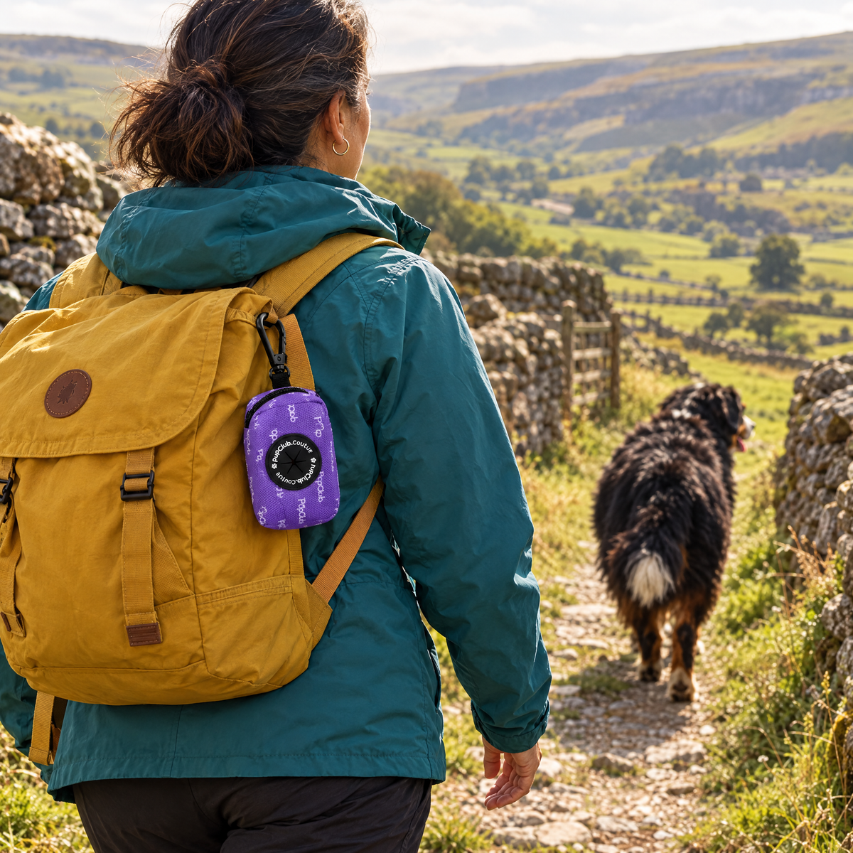 Lilac Blush poo bag holder clipped to a backpack on a dog walk