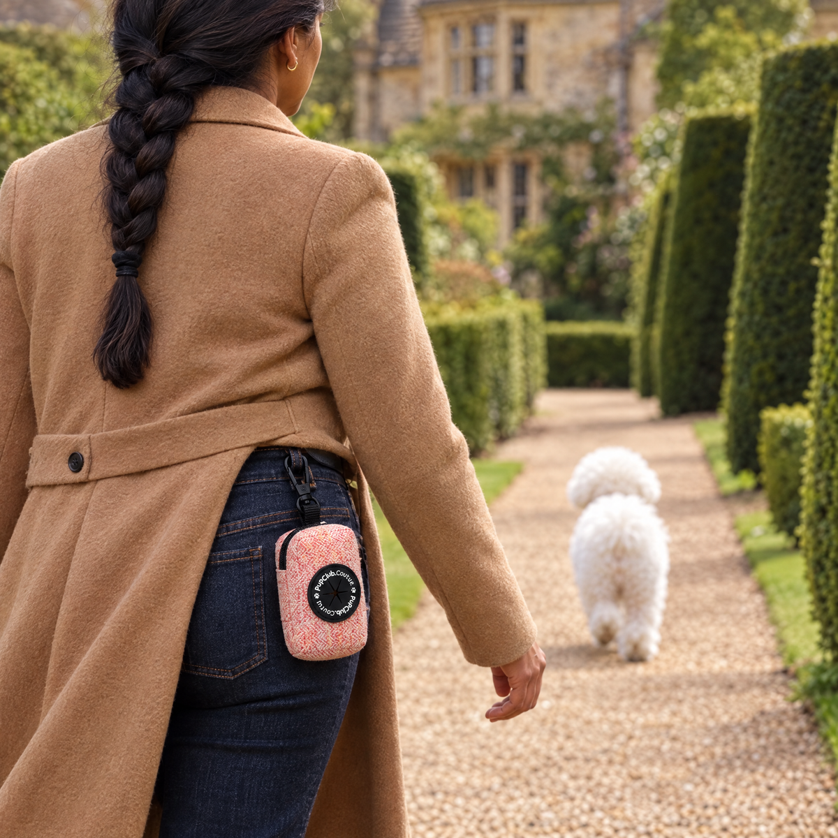 Tweed Pink poo bag holder clipped to a belt on a dog walk