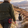Red Tartan poo bag holder clipped to a belt on a dog walk