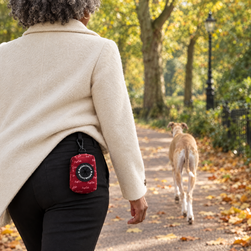 Berry Red poo bag holder clipped to a belt on a dog walk