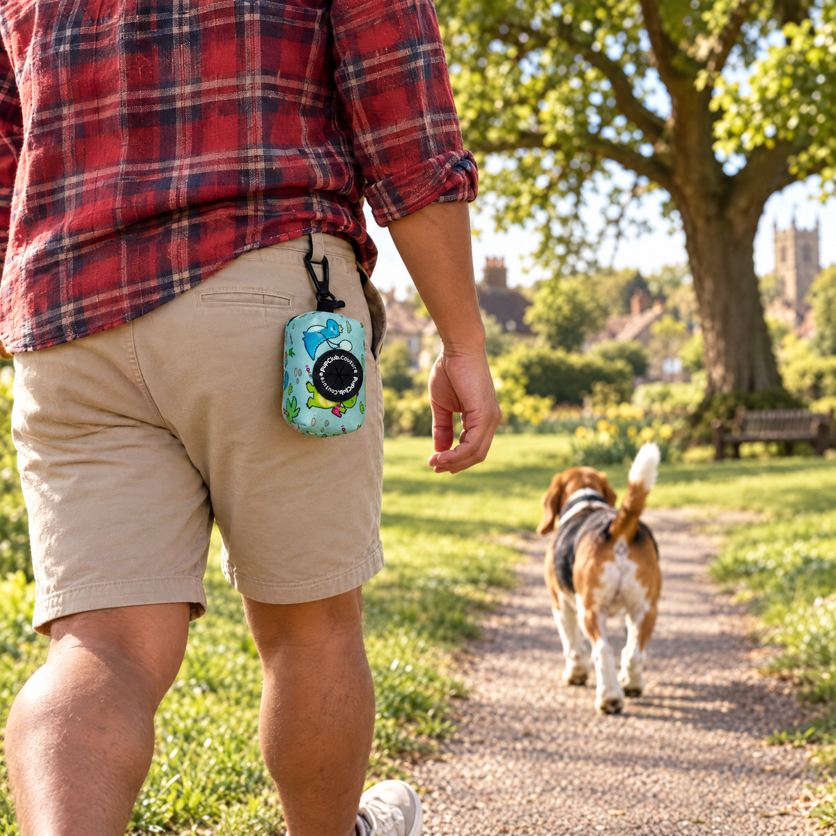 Jurassic Party poo bag holder clipped to a belt on a dog walk