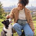 Woman giving her dog a treat from the Grey dog walking bum bag by PupClub Couture