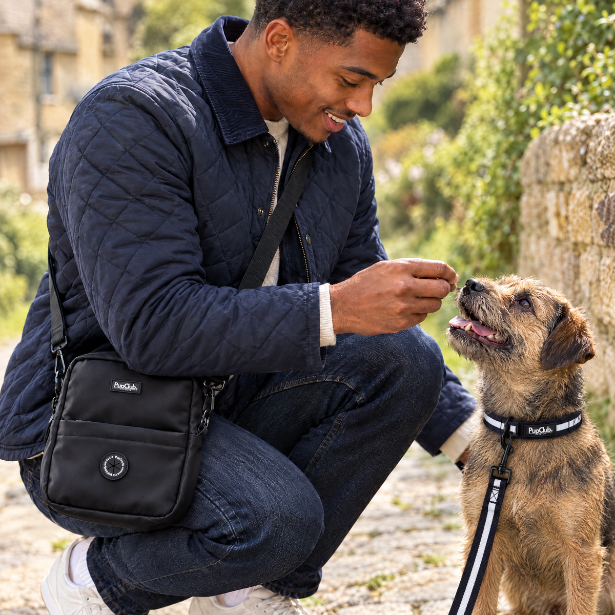 Close-up of the Black mini dog walking bag by PupClub Couture worn at the hip